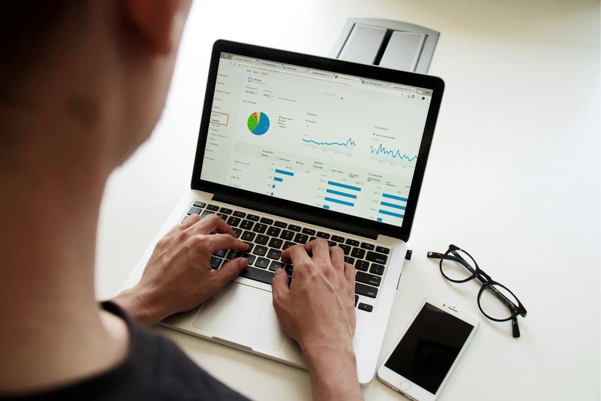 Une personne consulte un tableau de bord avec des graphiques simples sur son ordinateur portable.
